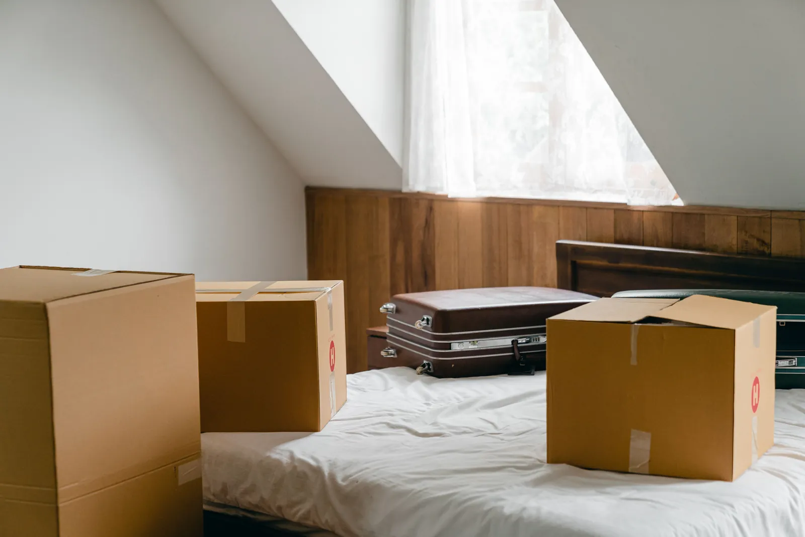 Umzugskartons und Koffer in einem Dachzimmer